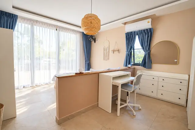 Bright bedroom with desk and blue curtains